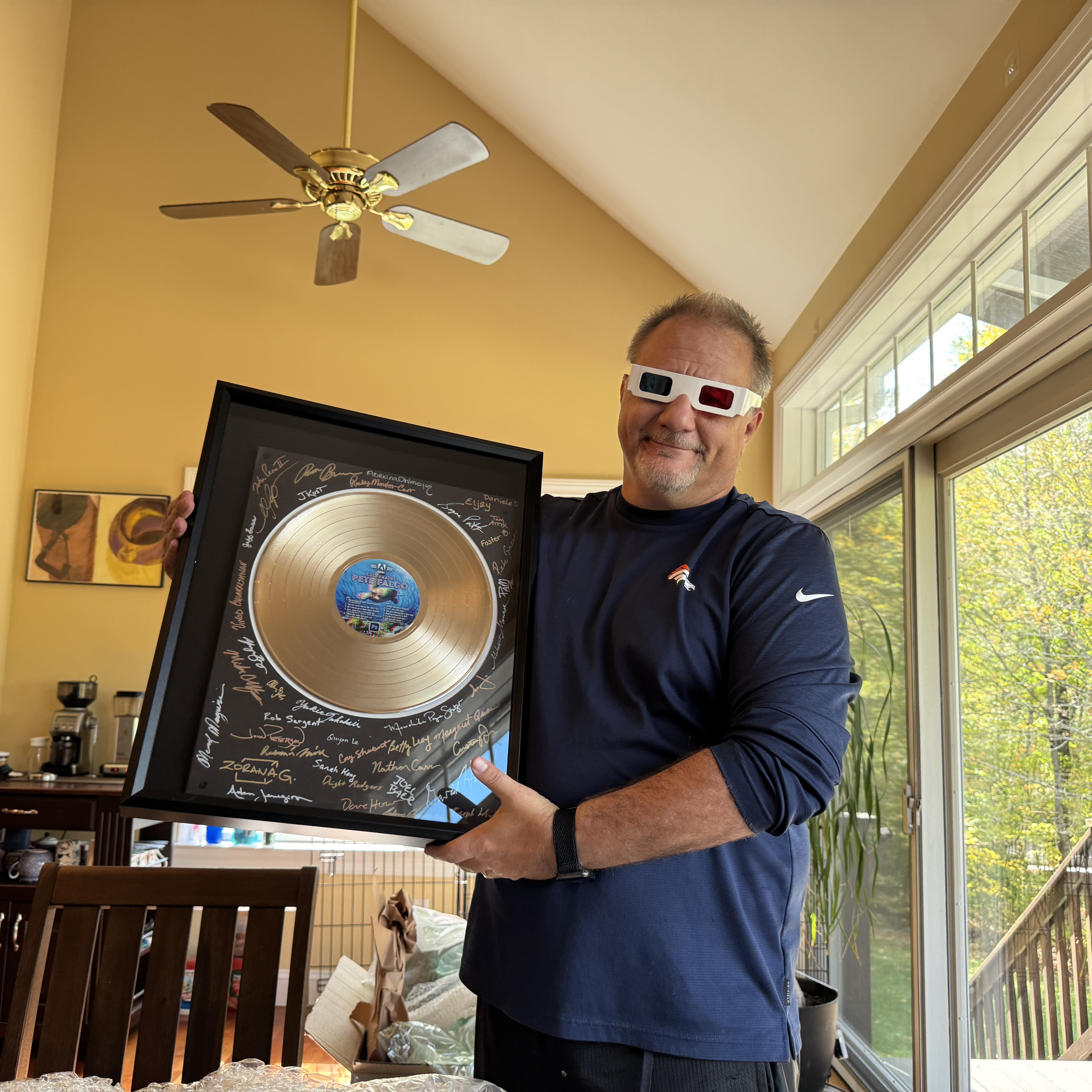 Pete Falco holding a framed commemorative record given to him at retirement.
